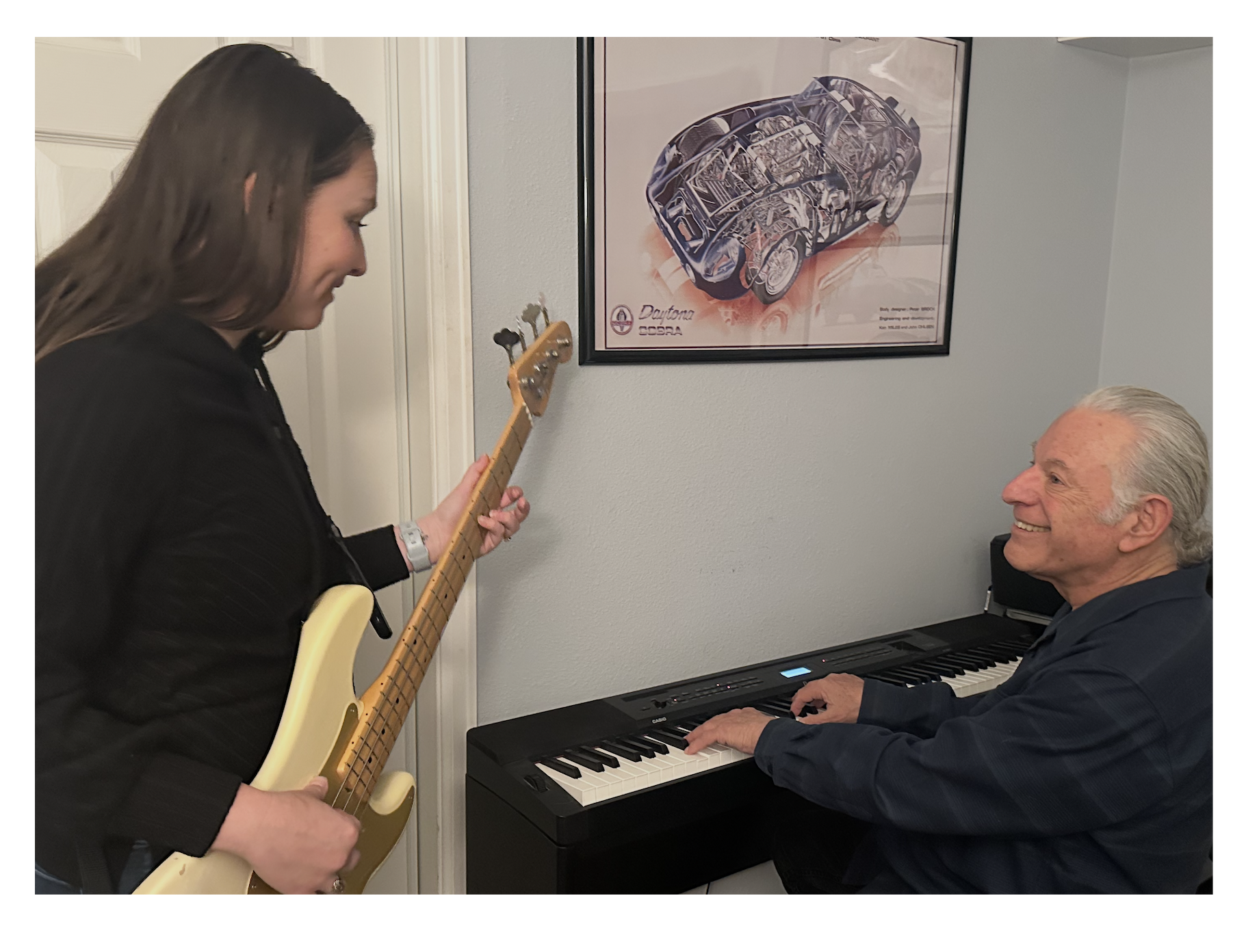 Tom giving a bass lesson to Kristina while seated at the piano.