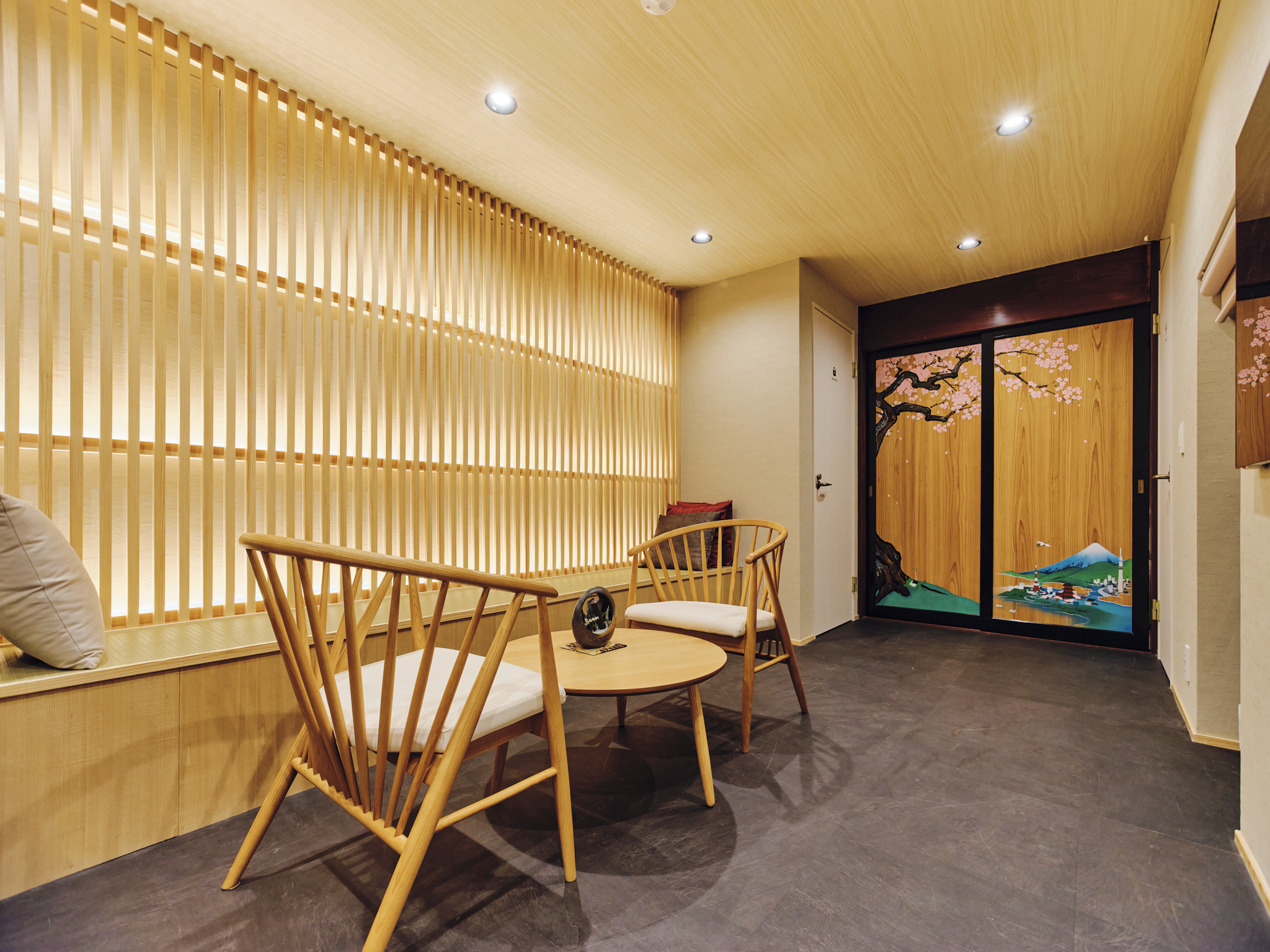 Interior of a room with wooden furniture, a sliding door with a landscape painting, and soft lighting.