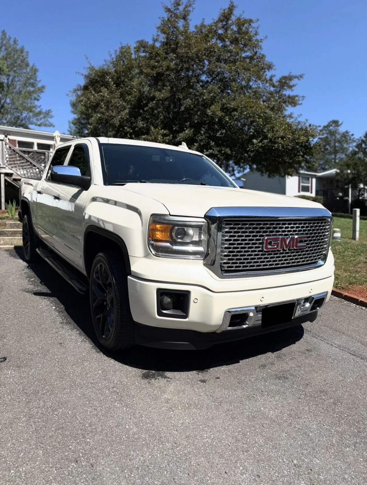 White GMC Denali freshly waxed and detailed outside on a sunny May day