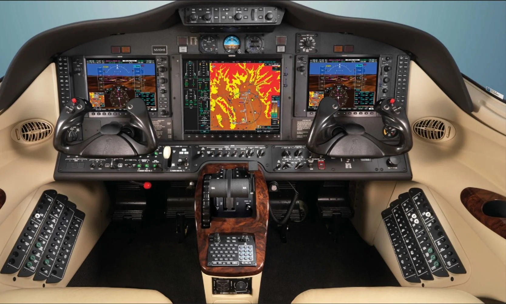 A modern airplane cockpit with multiple digital screens, control levers, and instrument panels.