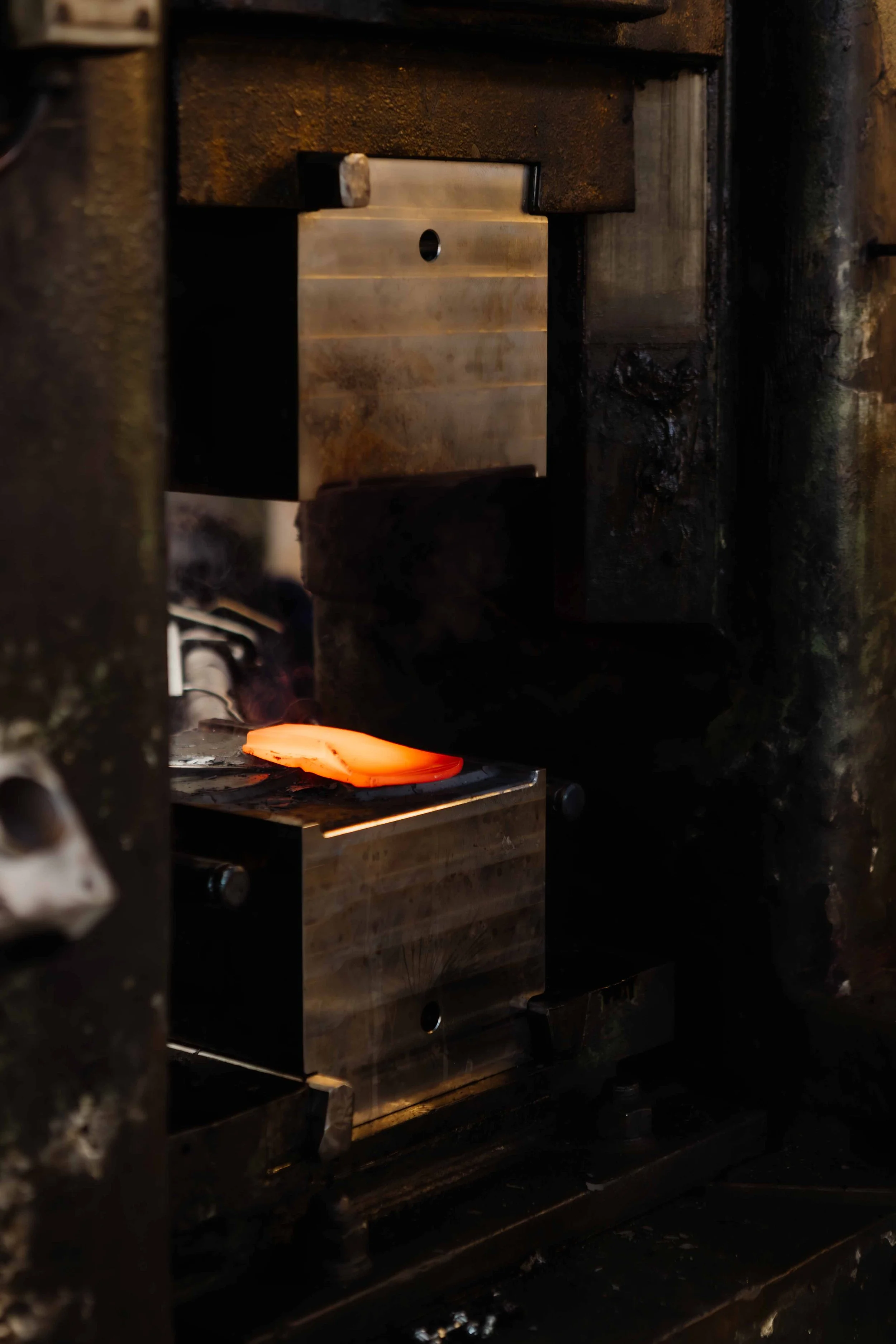 A hot piece of metal being shaped in a blacksmith's forge with a glowing, fiery orange appearance.