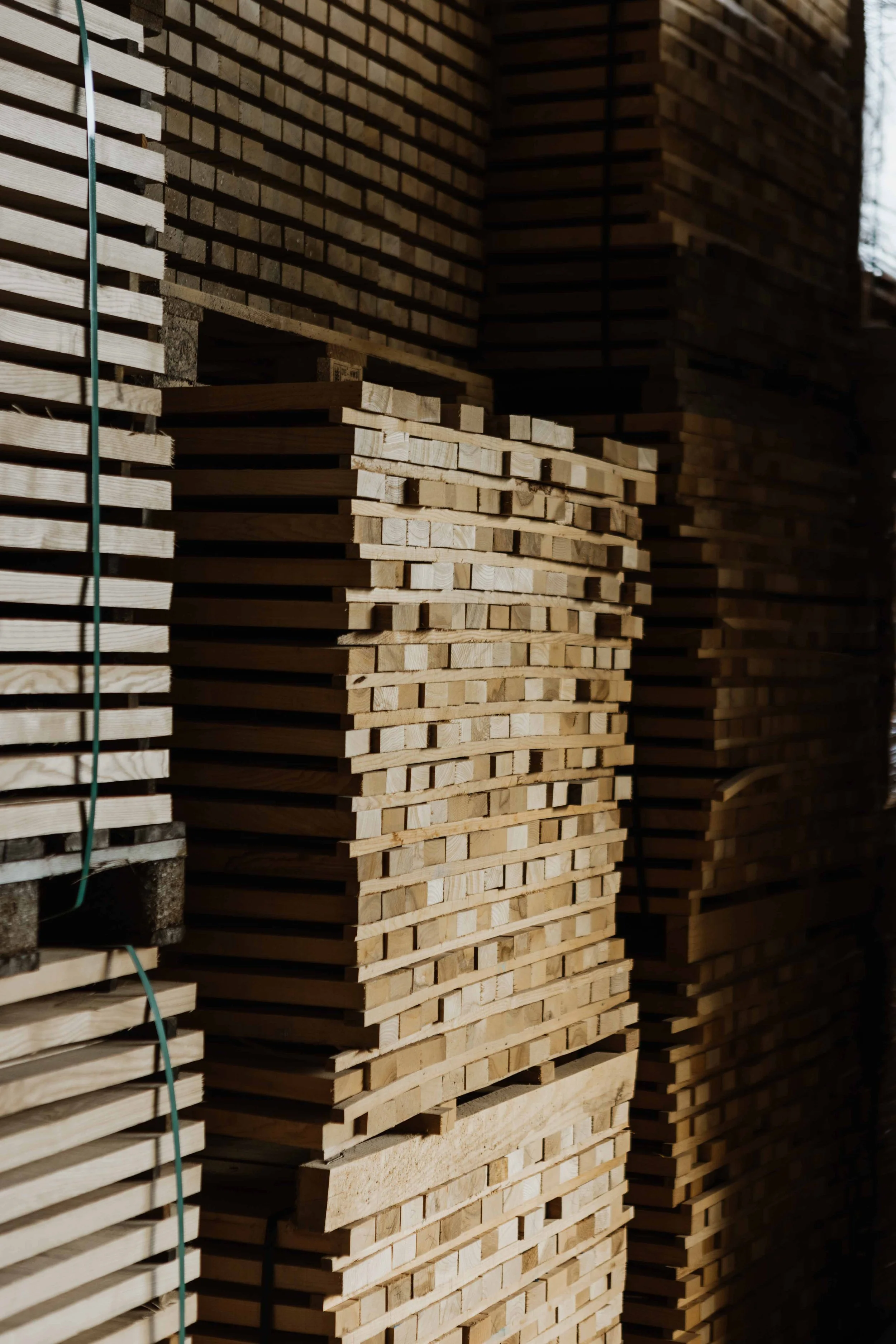 Stacks of wooden planks and boards stored in a warehouse or lumber yard.