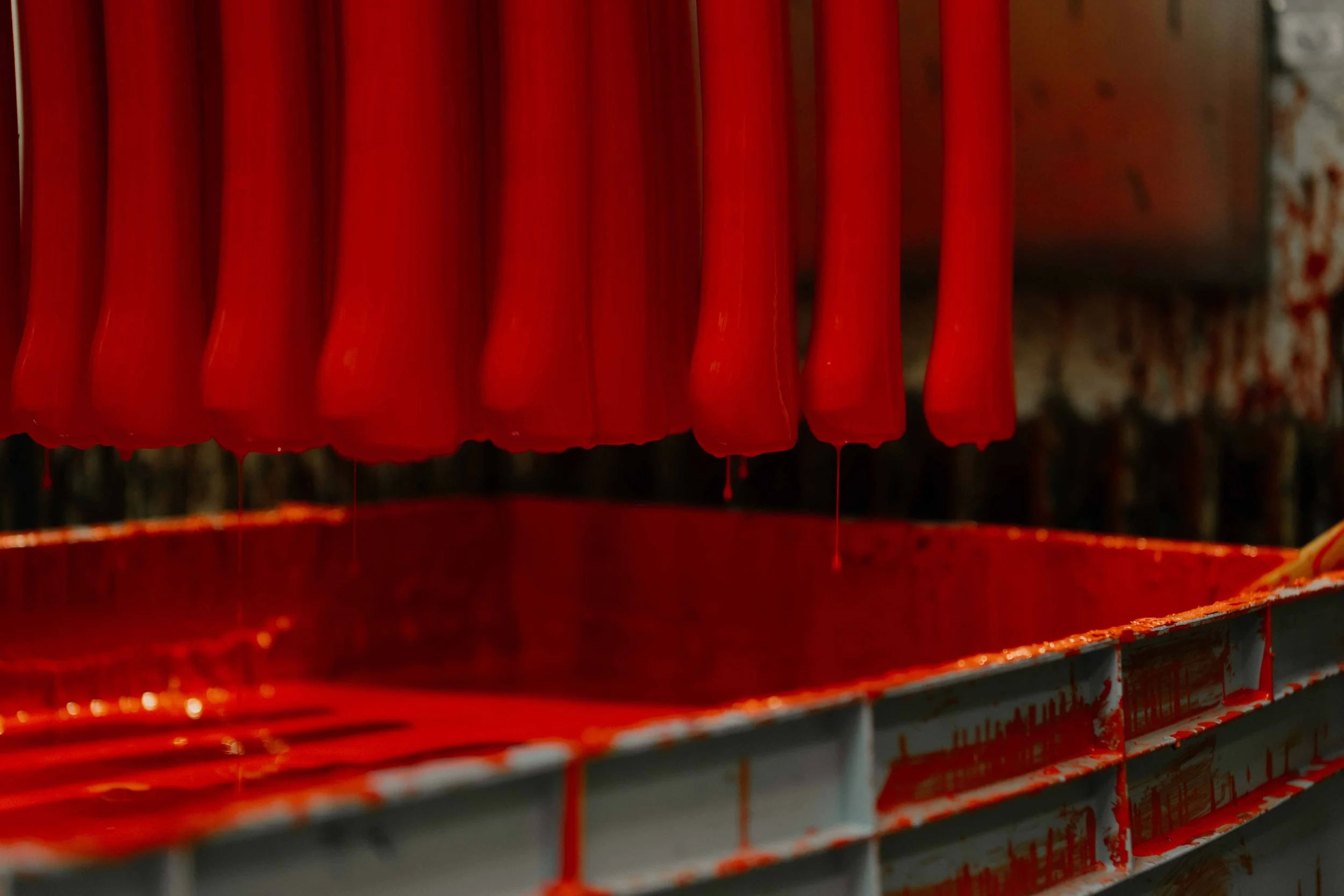 Red candles dripping wax above a red container.