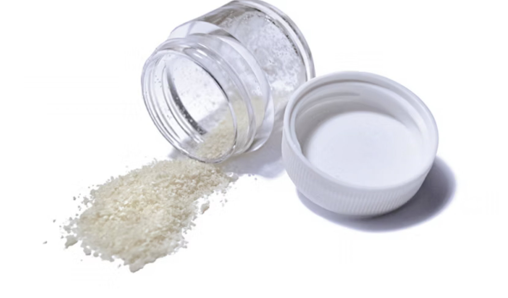 White powdered substance spilled from a glass jar into a small white bowl.