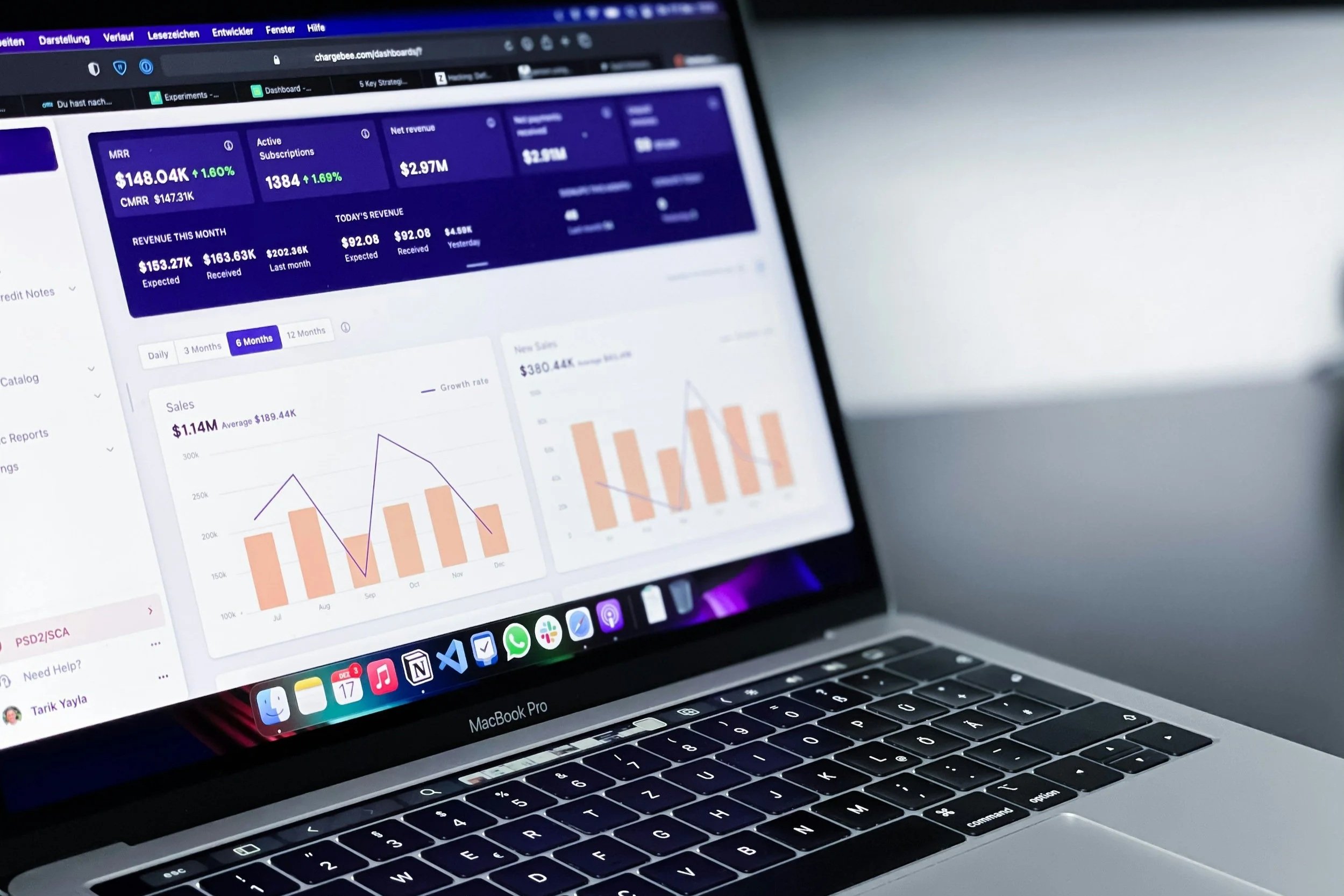 Open MacBook Pro displaying a financial dashboard with graphs, charts, and statistics related to sales and revenue.