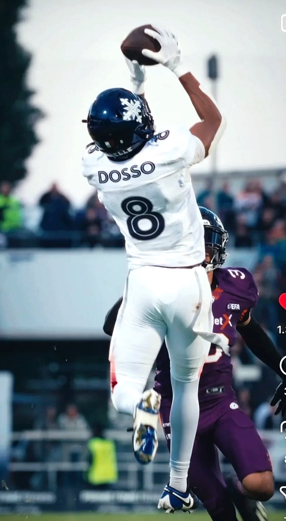 American Footballspieler in Action, fängt den Ball, trägt weißen Anzug mit der Nummer 8, und Helm mit S nach vorne