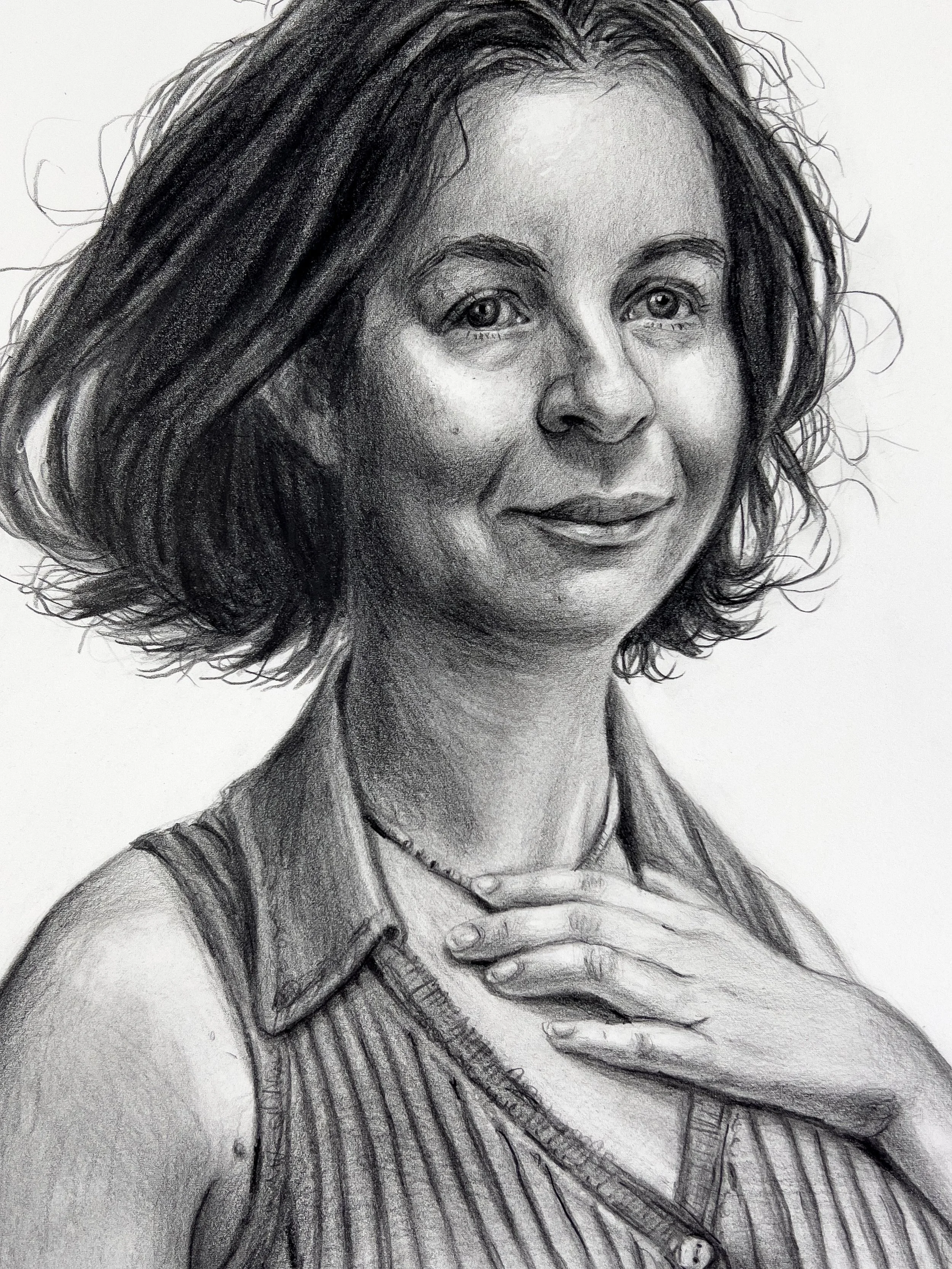 A detailed black-and-white pencil sketch of a woman with shoulder-length wavy hair, smiling slightly, wearing a sleeveless striped top and a necklace, with her right hand gently resting on her chest.
