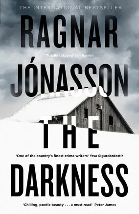Book cover of 'Darkness' by Ragnar Jónasson featuring a snow-covered barn under a cloudy sky.