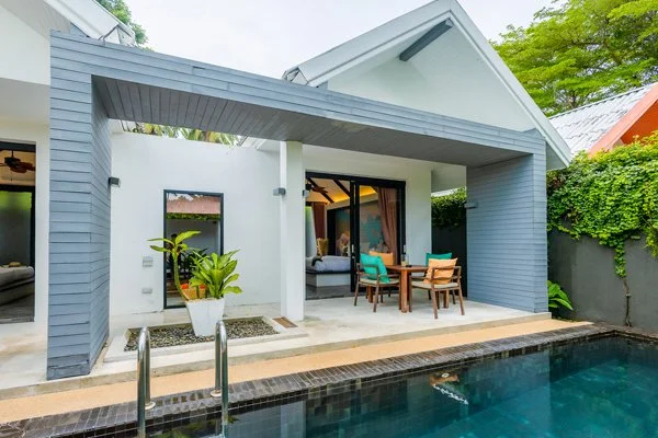 Modern backyard with a covered patio, outdoor dining area, and a swimming pool.