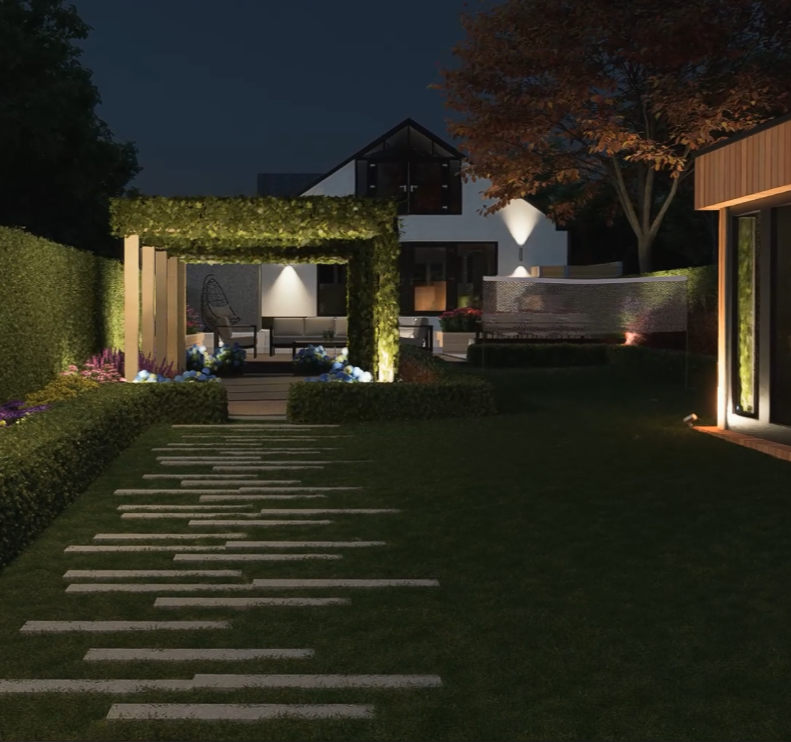 Night view of a modern backyard with illuminated pathways, landscaped bushes, flowers, a seating area with a swing chair, a tiered fountain, and a contemporary house with large glass windows and a sloped roof.