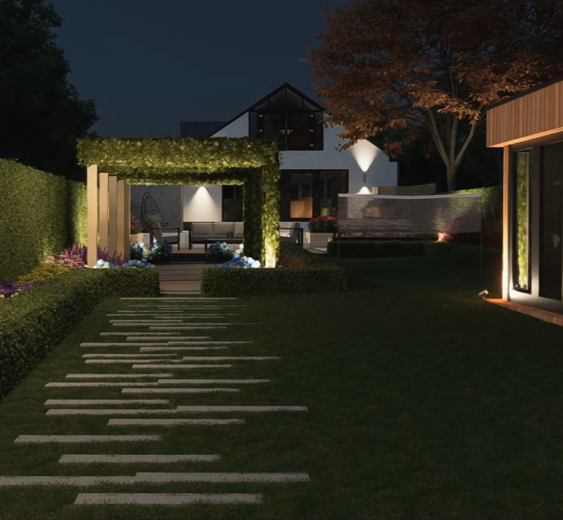 Night view of a modern backyard with a walkway, illuminated seating area, plants, trees, and a contemporary house in the background.