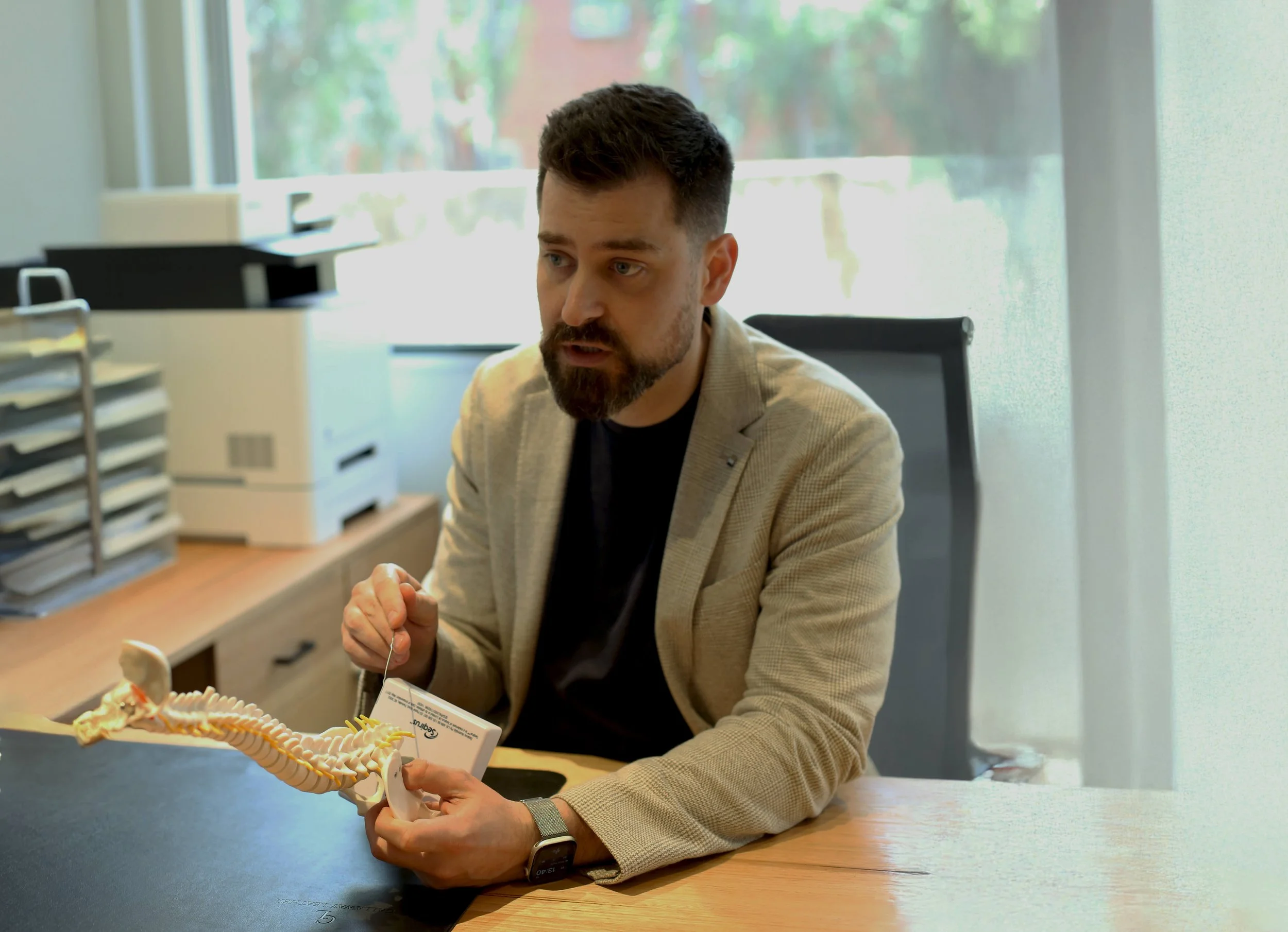 Dr Jeremy Tannenbaum, specialist pain medicine physician and psychiatrist in Perth, Western Australia, explaining spinal anatomy during a psychiatry-informed pain assessment.