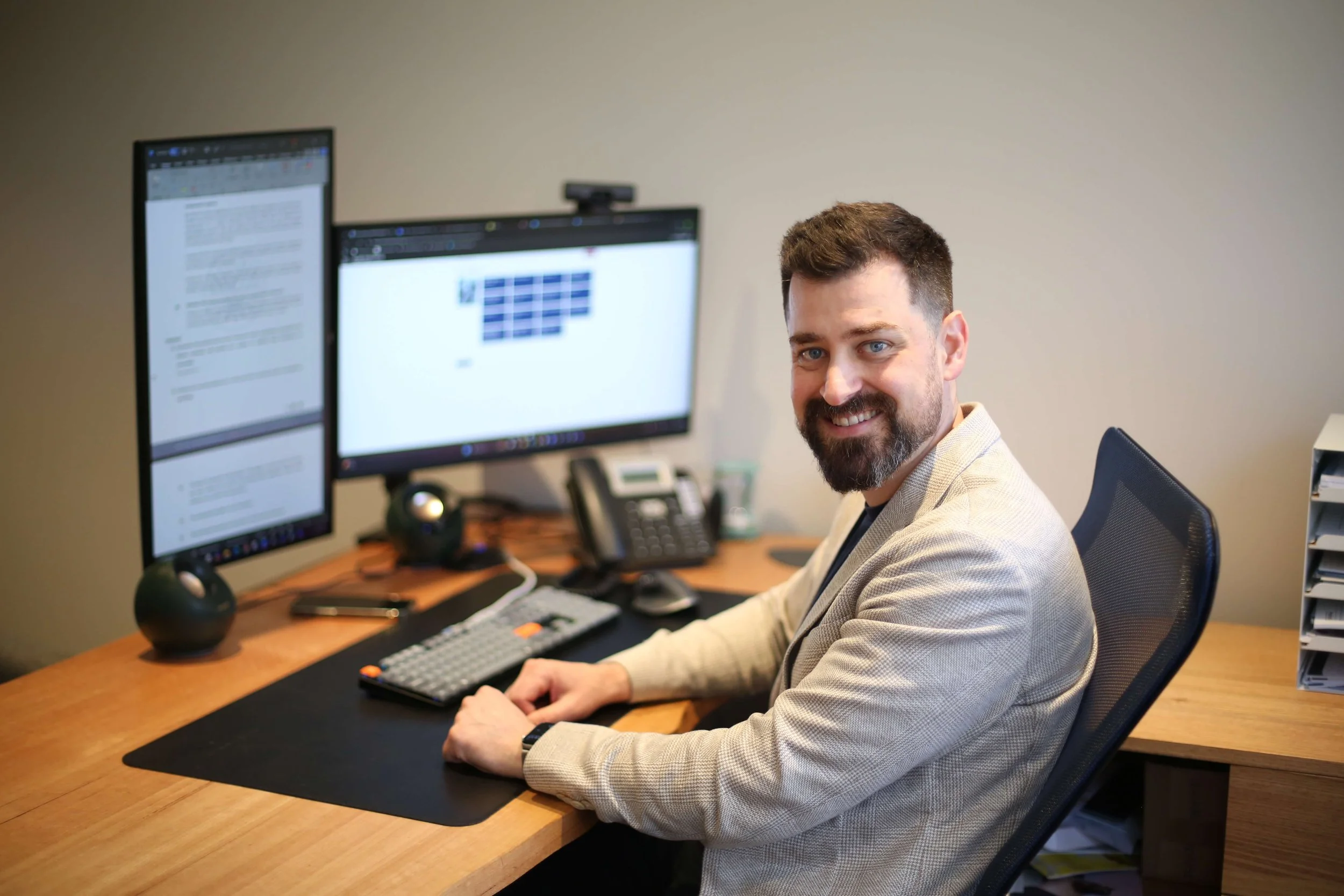Dr Jeremy Tannenbaum, specialist pain medicine physician, seated at a desk reviewing clinical information in a consultation room.