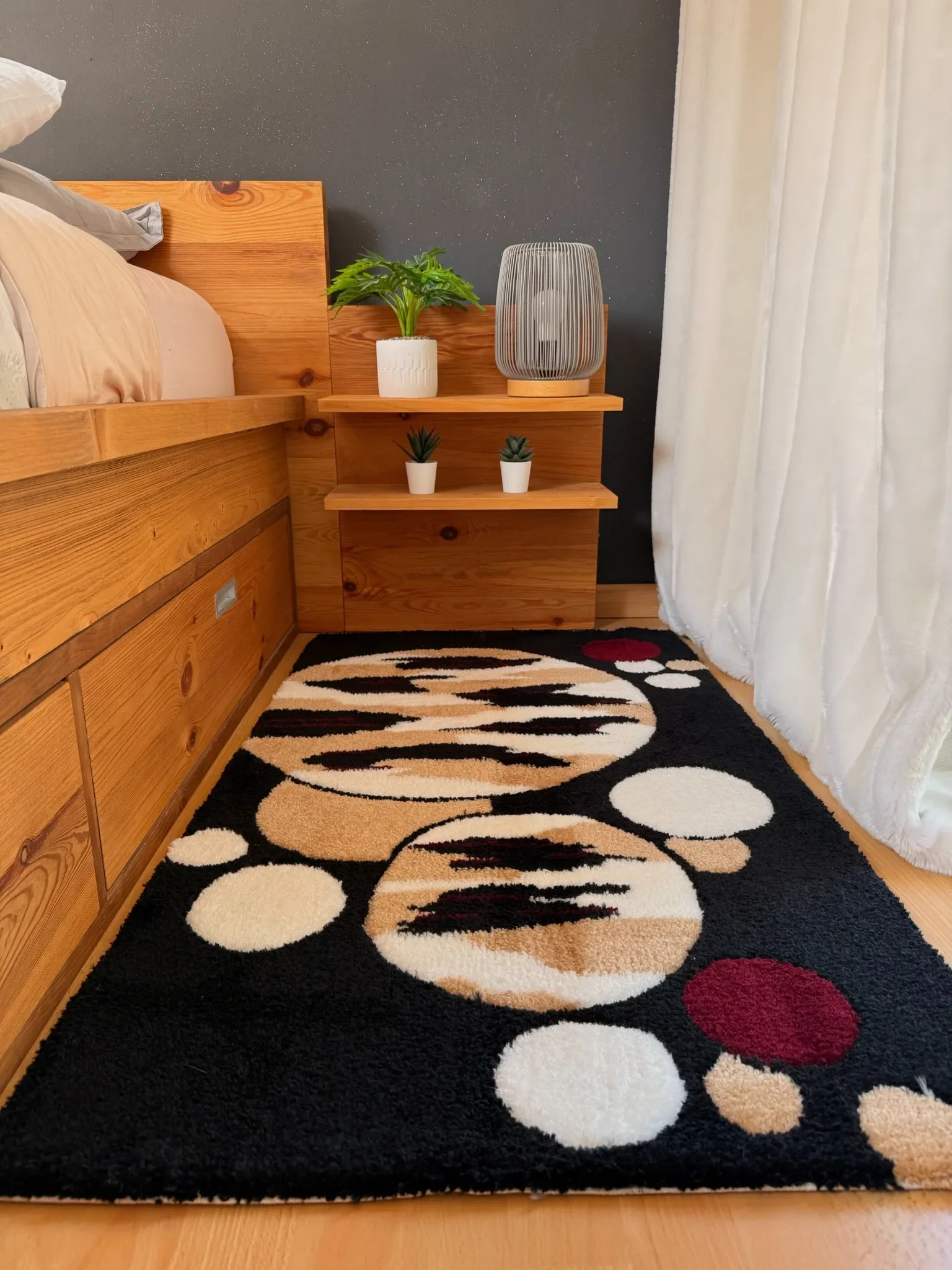 Descente de lit tuftée artisanale au design contemporain noir, beige et bordeaux pour décoration intérieure chaleureuse.