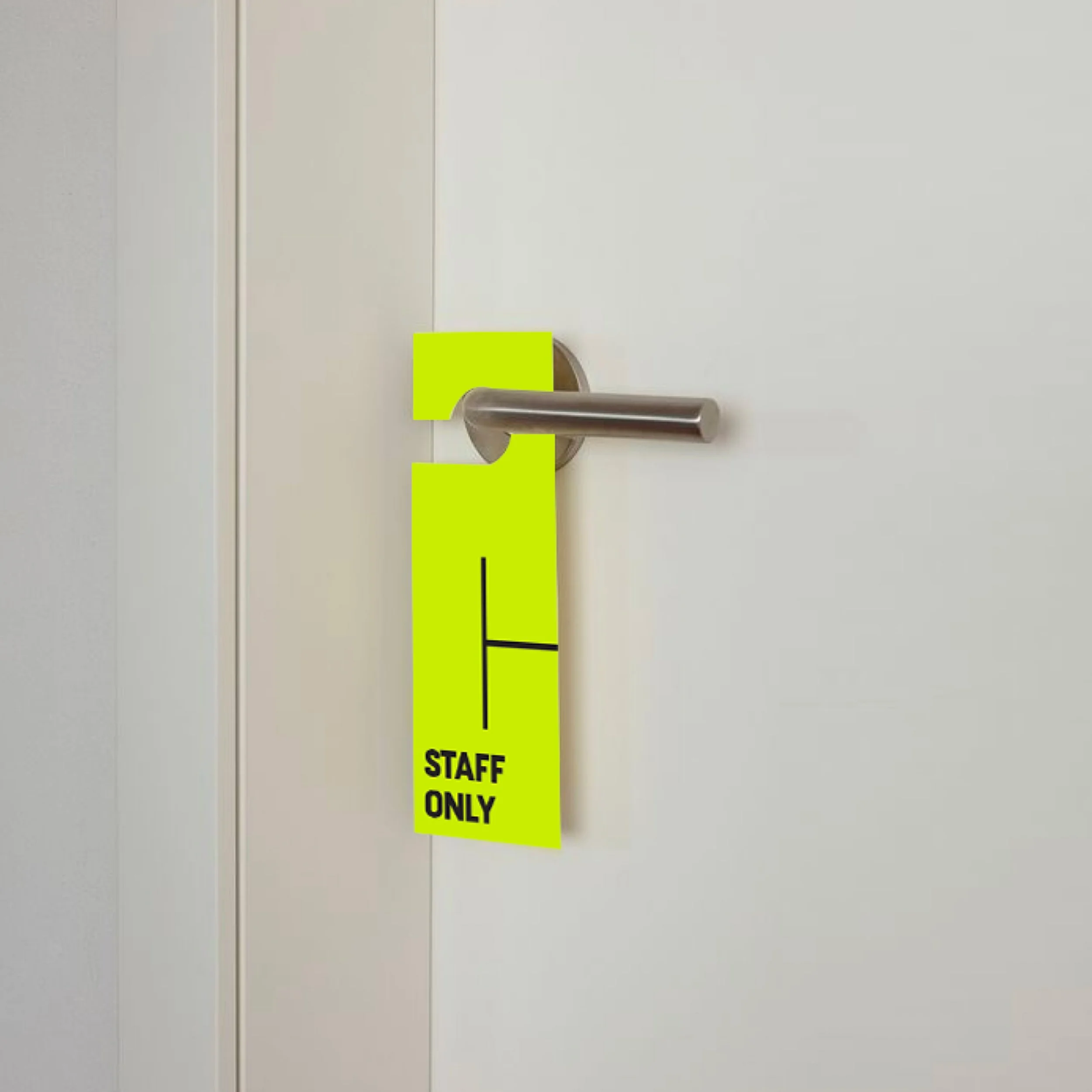 A door with a stainless steel handle and a bright yellow sign reading 'STAFF ONLY' hanging from the handle.