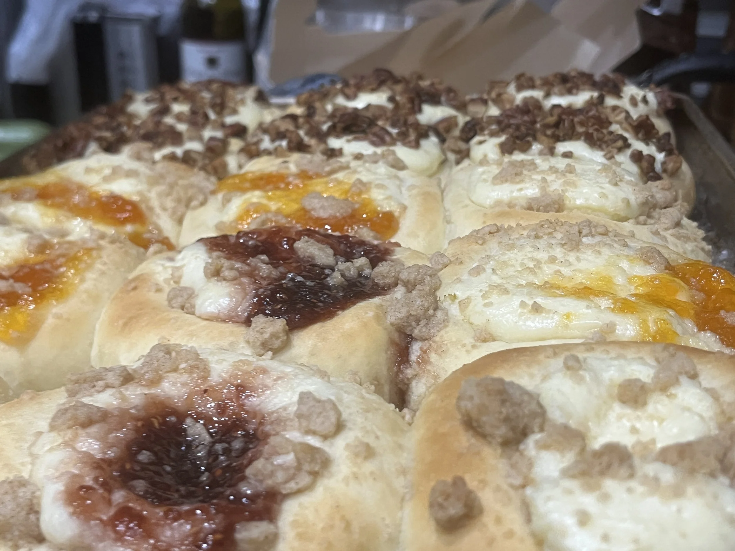 Close-up of assorted kolaches  with toppings like cheese, eggs, sausage, and bacon.