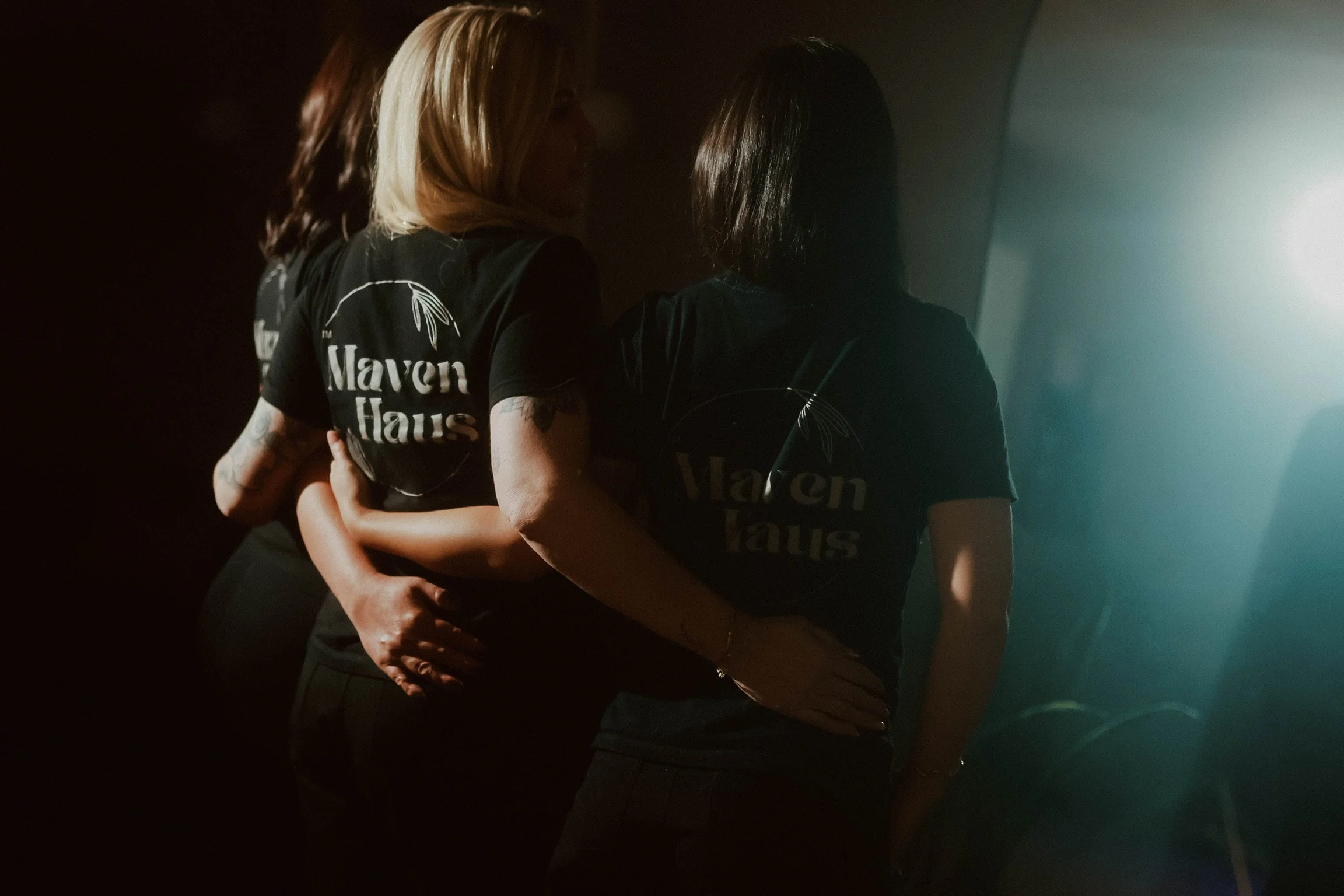 Maven Haus medspa collective hugging from the back in matching shirts in Vacaville CA