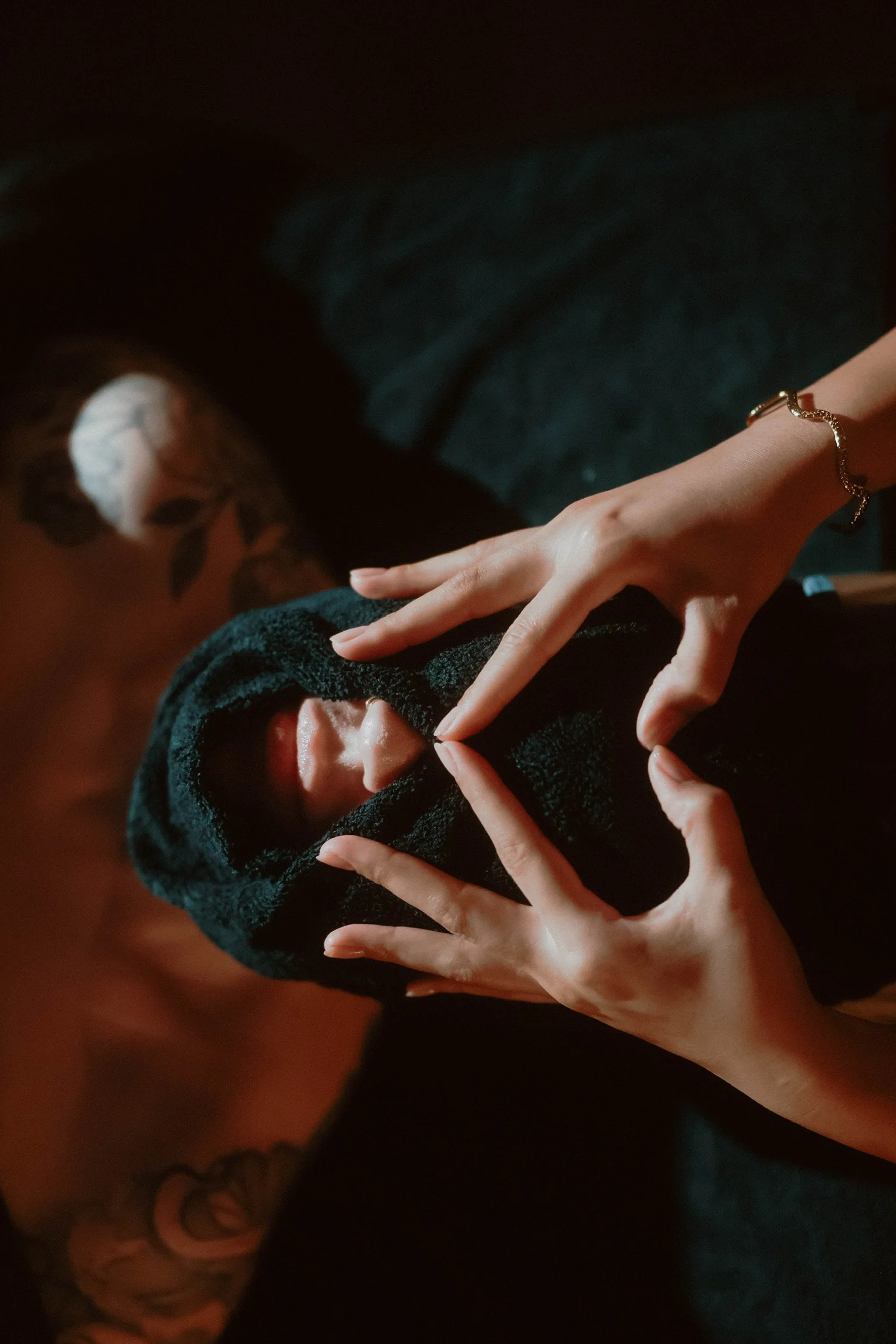 Maven Haus provider wearing a bracelet, making a heart shape with their hands around their face while wearing a black hoodie.