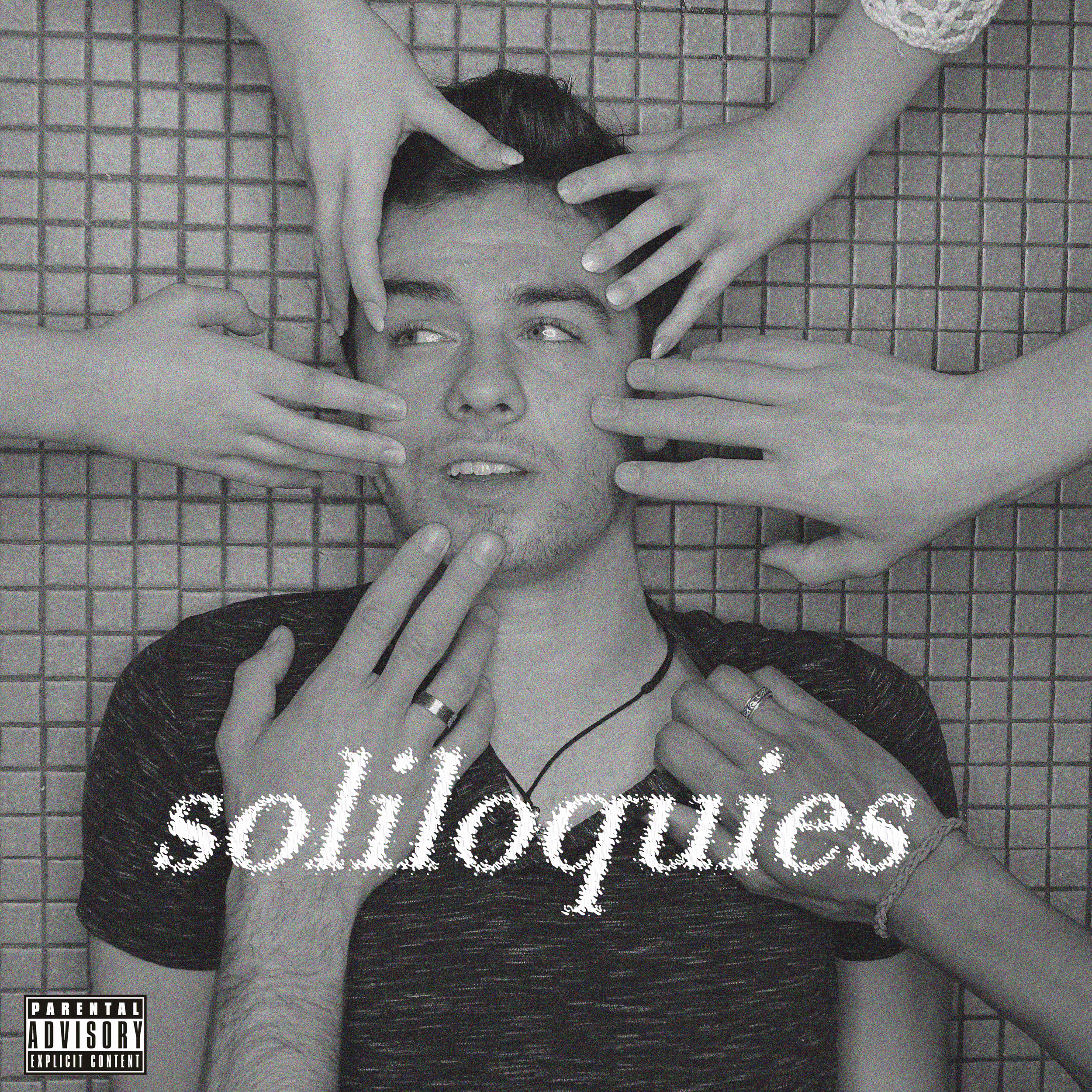 A young man lying on a tiled surface, surrounded by multiple hands touching his face and neck. The word 'soltiedades' is written across the image.
