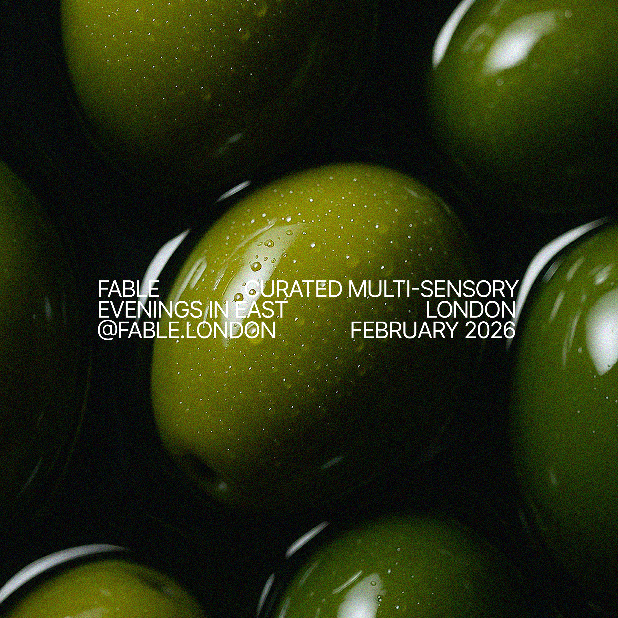 Close-up of green grapes with water droplets on a dark background, overlaid with white text advertising an event called Fable Curated Multi-Sensory Evenings in East London, February 2026, with a social media handle '@fable.london'.