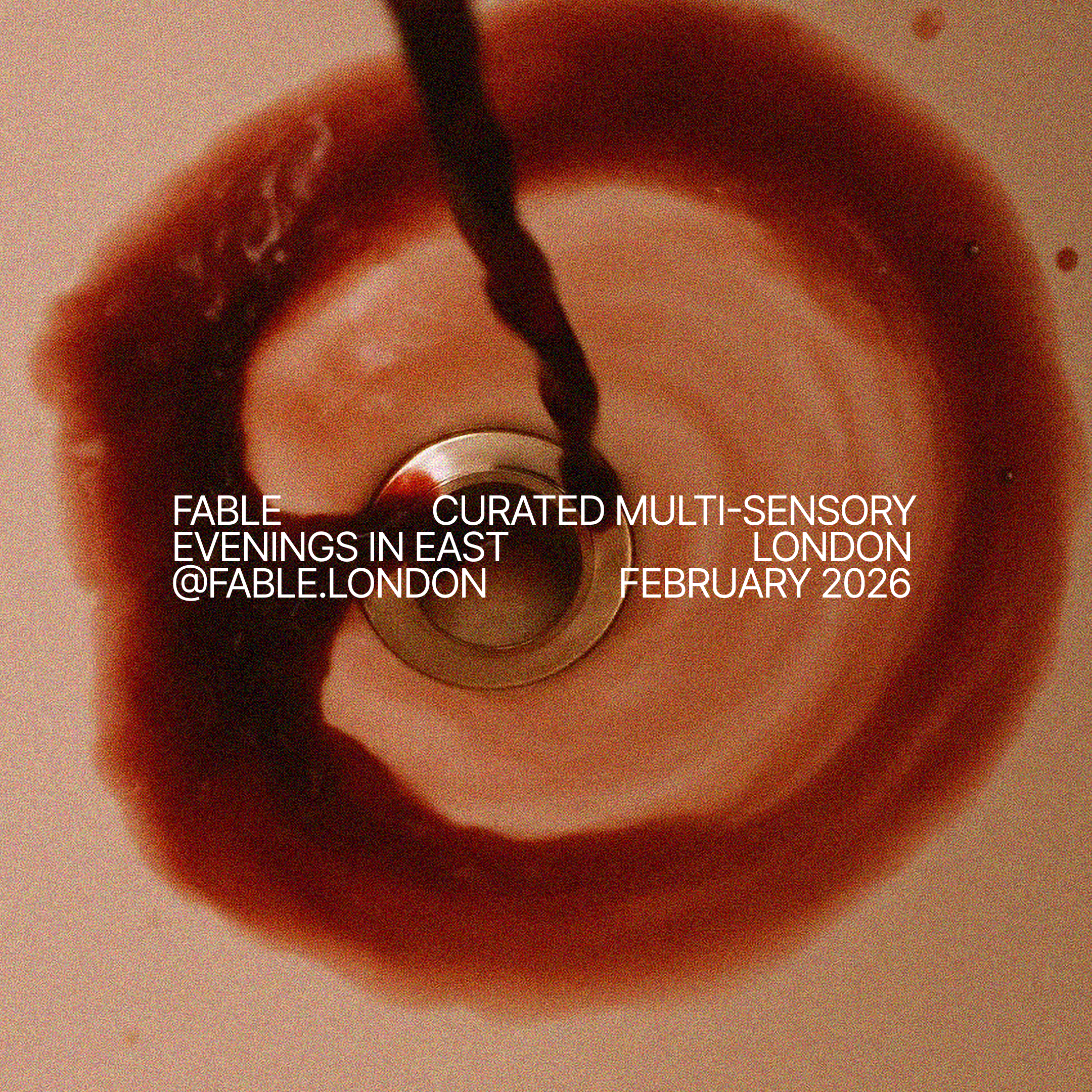An overhead view of a wine glass with a dark red beverage and a black spoon inside, with event information overlayed in white text for Fable London's curated multi-sensory evenings in East London in February 2026.