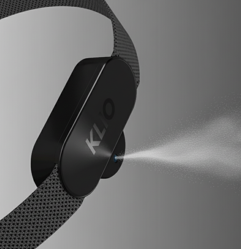A black fitness tracker with the brand name 'KLO' on it, spraying a mist of water against a gray background.