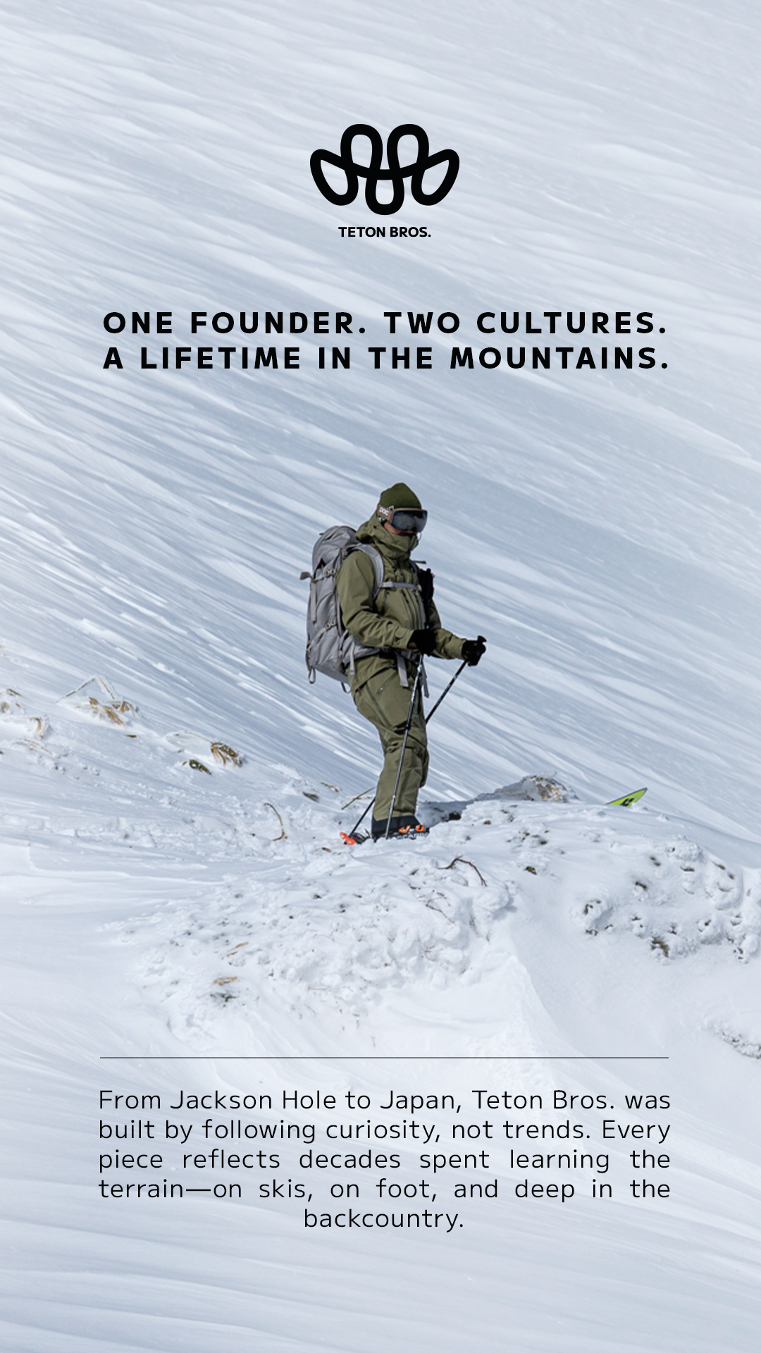 A person hiking in snowy mountain terrain, wearing green winter gear, goggles, and carrying a backpack, amidst a snowy landscape with slopes.