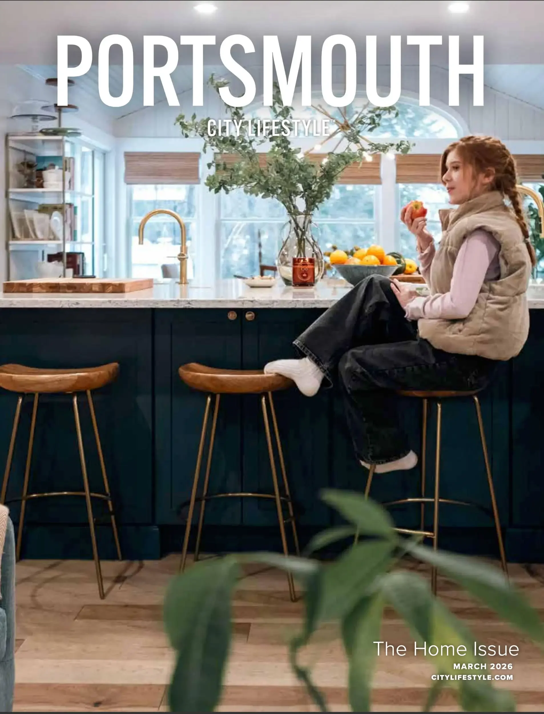 A woman sitting on a barstool in a bright, modern kitchen with a large green plant in a vase on the counter, holding an apple. The kitchen has white cabinets, a marble countertop, and large windows with blinds. The image features a caption that reads
