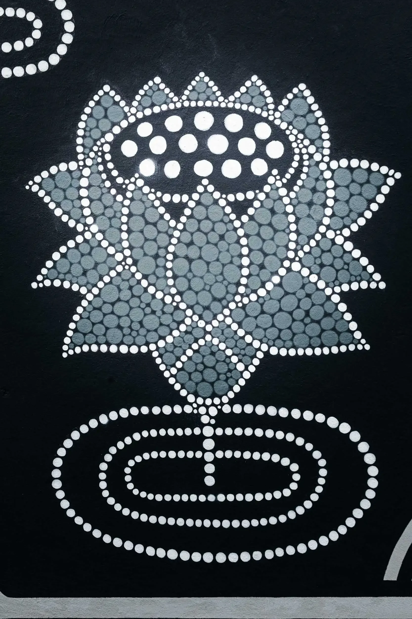Decorative design made with white dots on a black background, resembling a floral or mandala pattern.