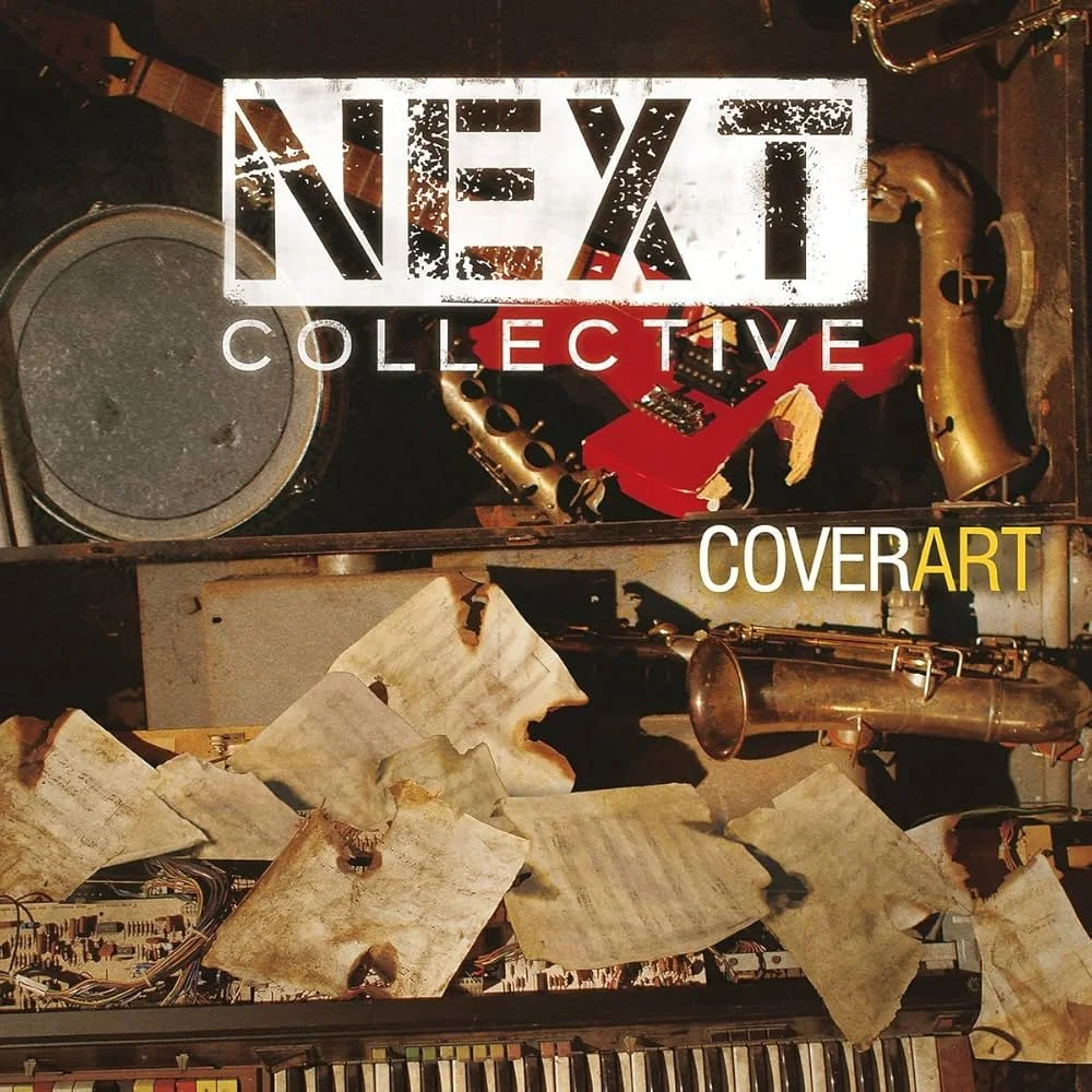 An art piece titled 'NEXT Collective' featuring musical instruments including a drum, a red electric guitar, a saxophone, and a keyboard with sheet music scattered around, combining vintage and musical elements.