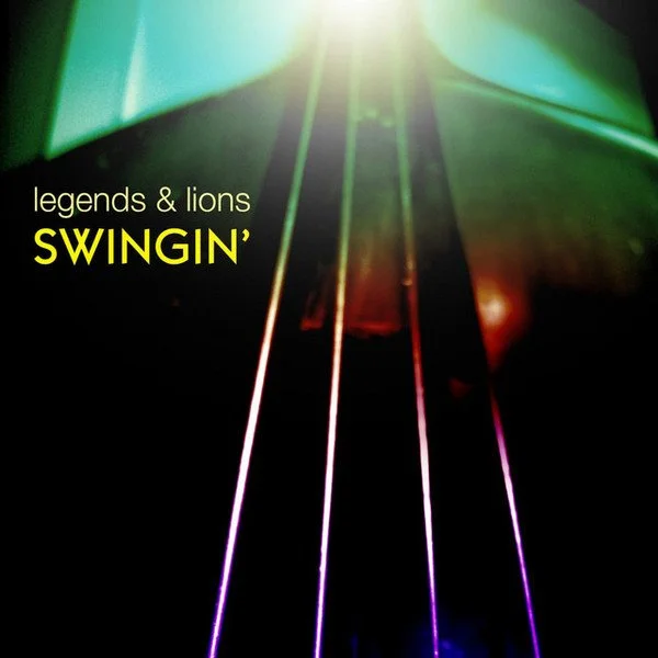 Close-up of neon-colored guitar strings with green, purple, and pink lighting, with text that reads 'Legends & Lions SWINGIN''
