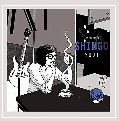A woman with glasses and shoulder-length hair sitting at a table, smoking a cigarette. There is a guitar leaning against the wall behind her, and a blue flower on the table. Text on the image reads 'Introducing Shingo Yuji'.