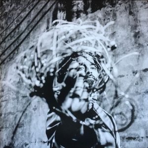 A black and white graffiti mural of a woman holding a microphone.