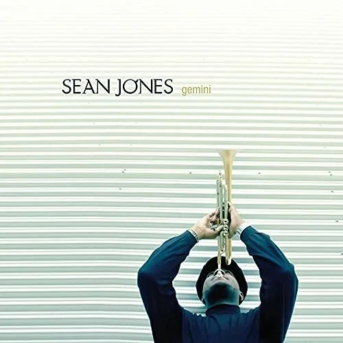 A person playing a trumpet in front of a striped wall with the text 'SEAN JONES gemini' at the top.