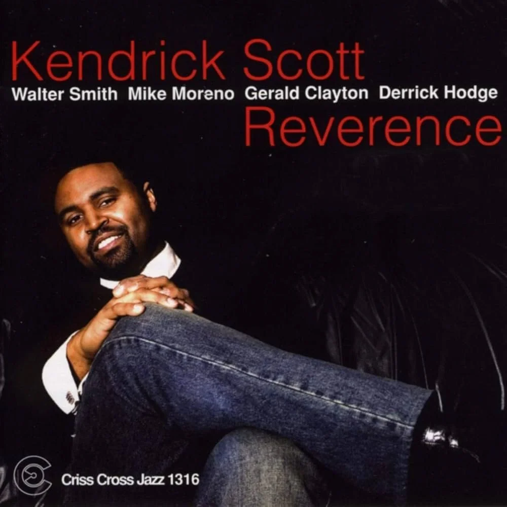 Album cover featuring Kendrick Scott with his name and the album title 'Reverence' in red text, along with the names of other artists and the record label 'Criss Cross Jazz 1316'. A photo of Kendrick Scott shows him sitting in a black leather chair, 