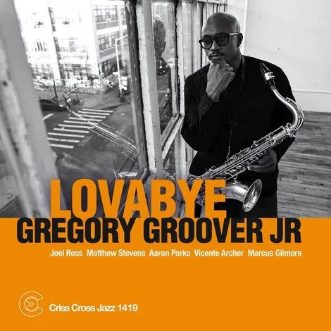 Album cover for 'Lovabye' by Gregory Groover Jr., featuring a man with sunglasses holding a saxophone, standing near a window with city streets outside.