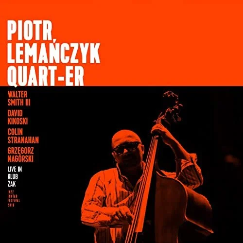 Album cover featuring a male jazz musician playing a double bass with black sunglasses, set against an orange and black background, with text listing the musicians and event details.