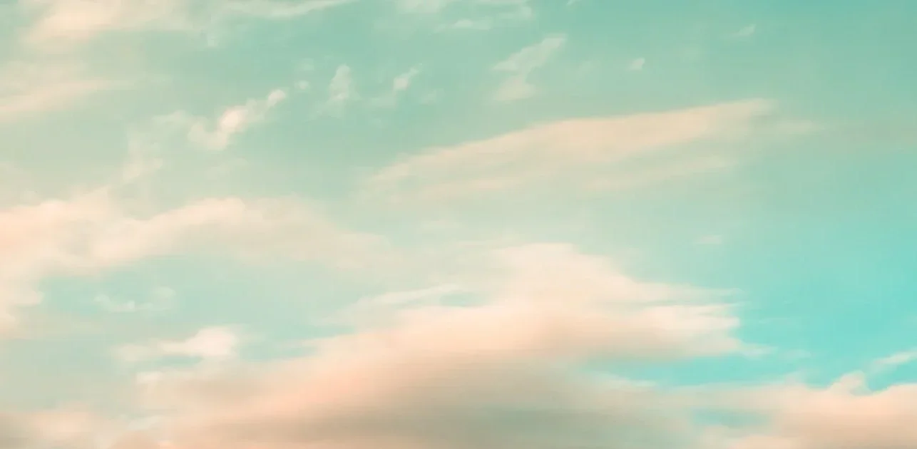 Sky with scattered clouds and a gradient of pastel colors