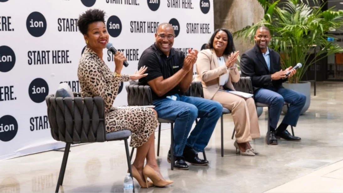 Four people seated on chairs at a panel, with a backdrop featuring the words 'START HERE.' and the 'ion' logo, participating in a discussion or presentation.