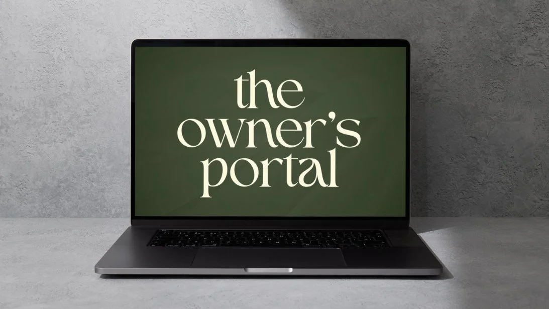 Laptop on a concrete surface displaying the text 'the owner's portal' on a green background.