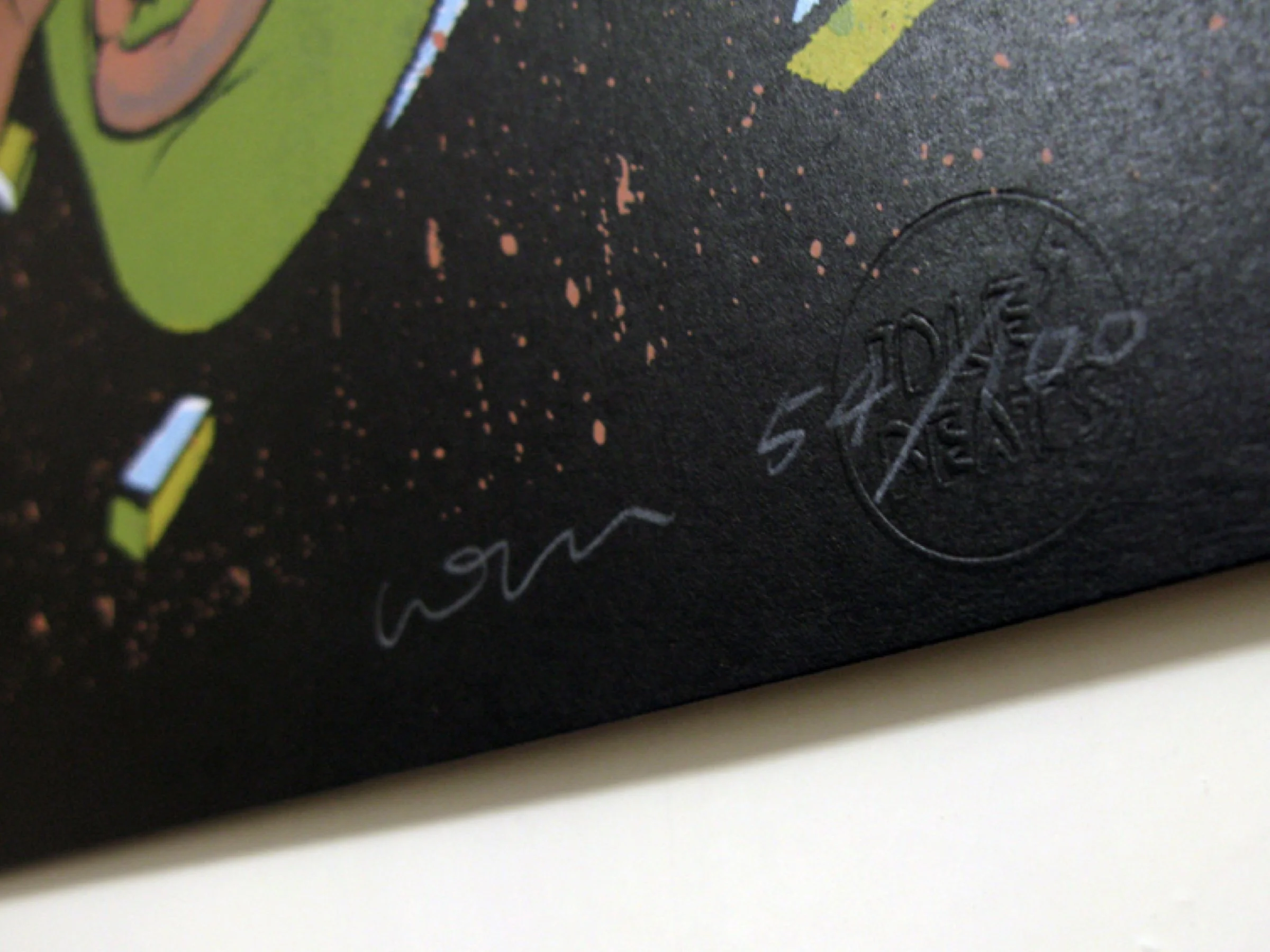 Macro shot of the handwritten signature and edition numbering on the art print.