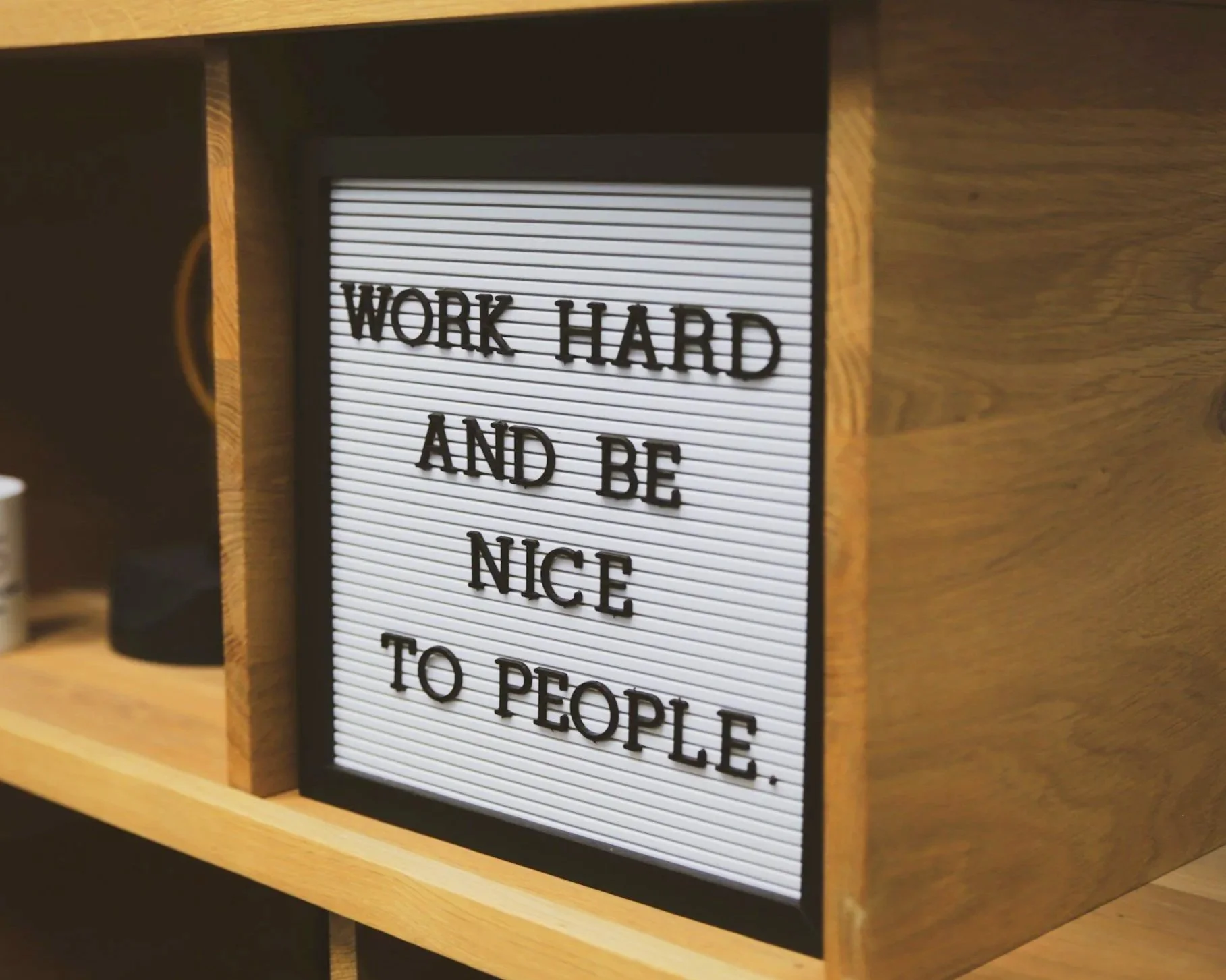 Placard with phrase "work hard and be nice to people".