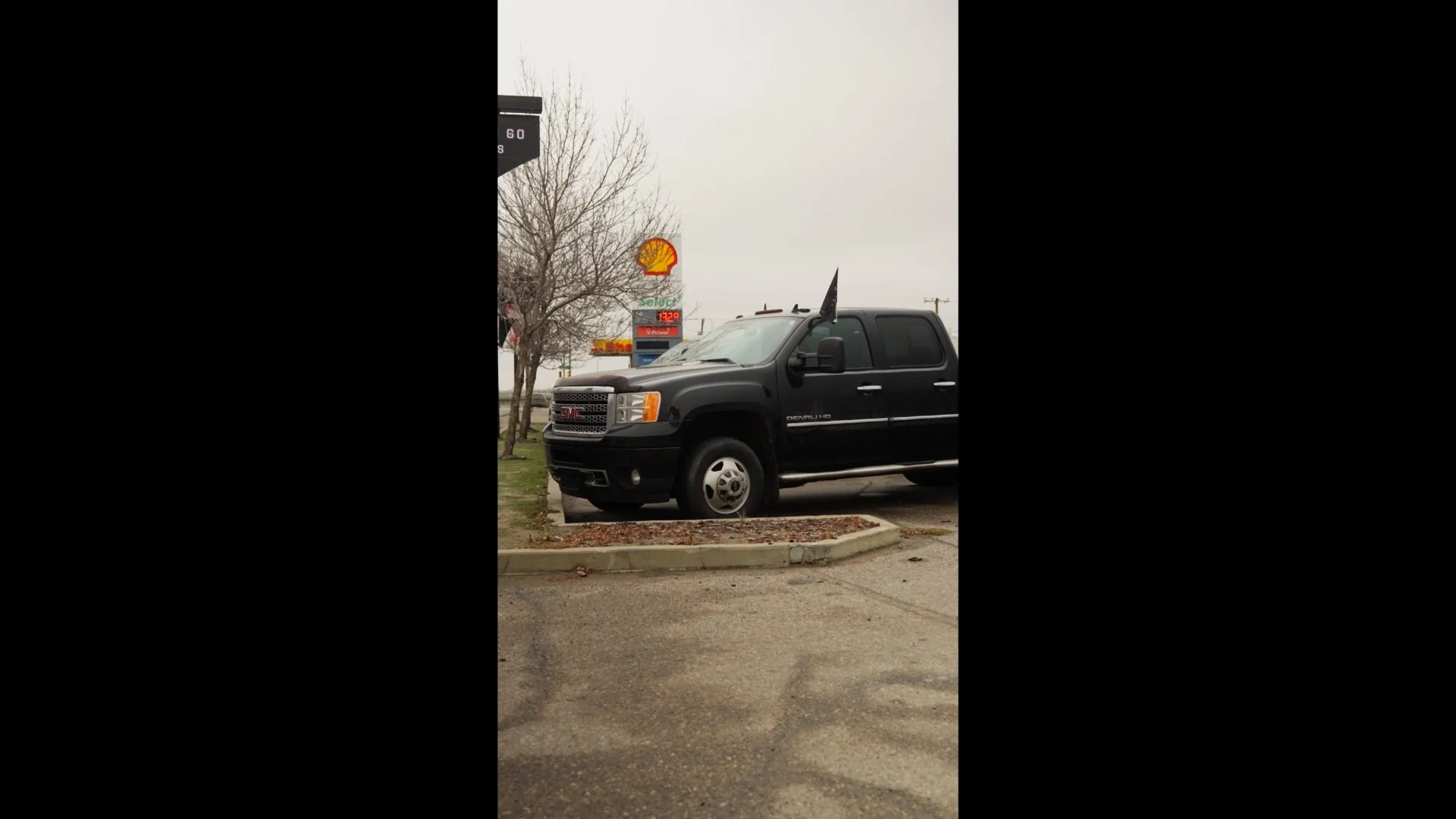 A black GMC Denali HD pickup truck at a dealership