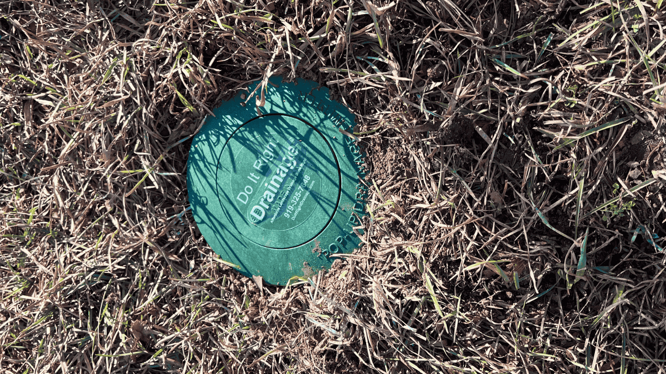 Do It Right Drainage drain marker in grass and soil—on-site drainage assessment for residential yard drainage in the Triangle Area, NC.