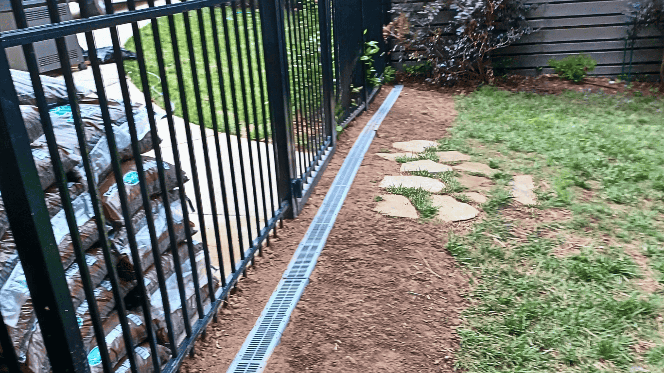 Solid PVC drainage line set in gravel and filter fabric—residential drainage system installation to prevent standing water in Cary, NC.