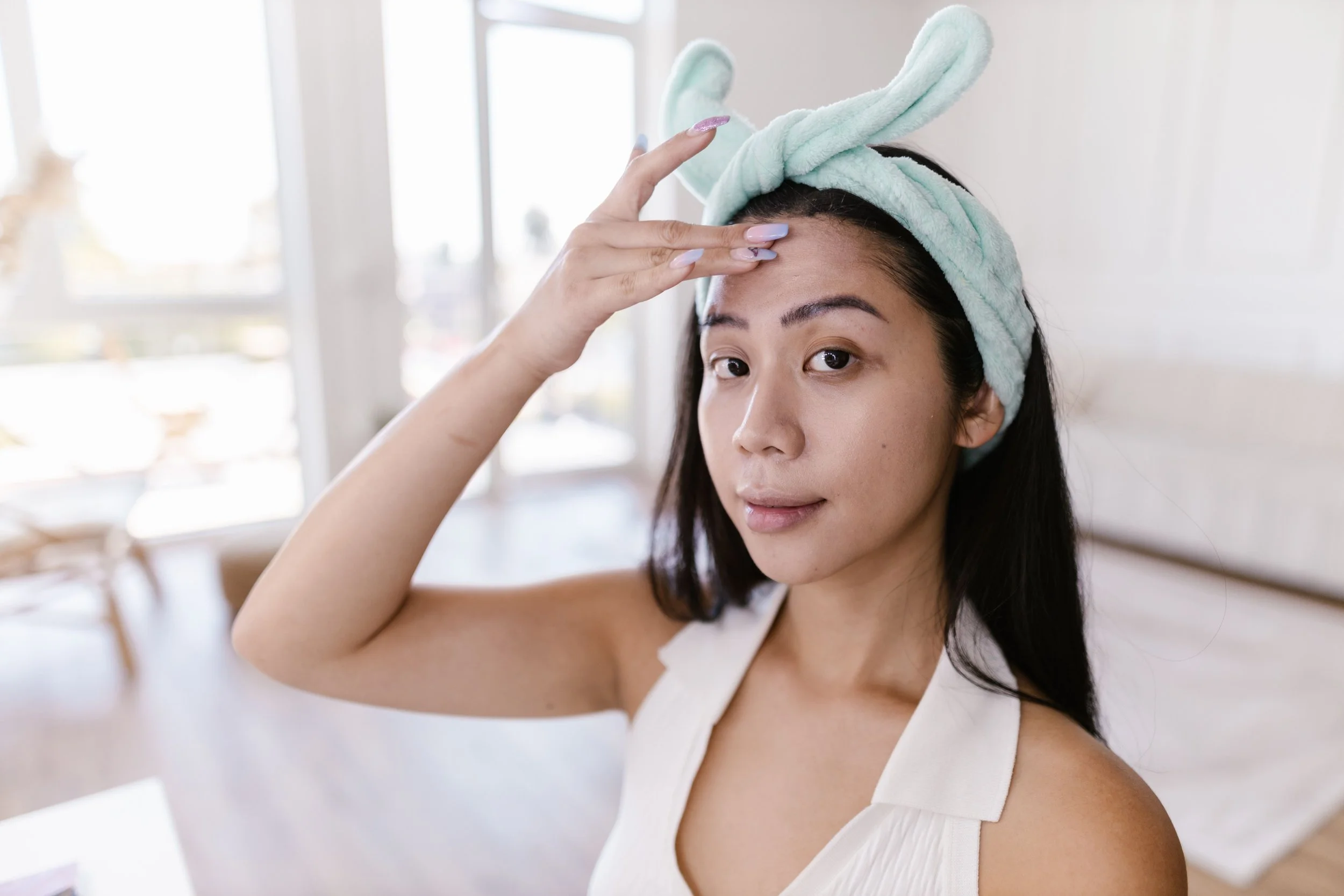 Person applying barrier cream to red, irritated cheeks after simplifying skincare