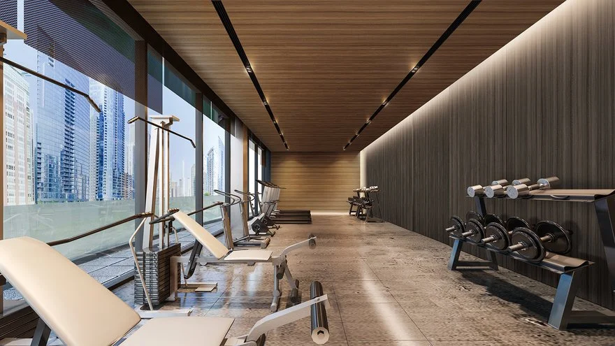 Empty modern gym with workout equipment and large windows overlooking city skyscrapers.