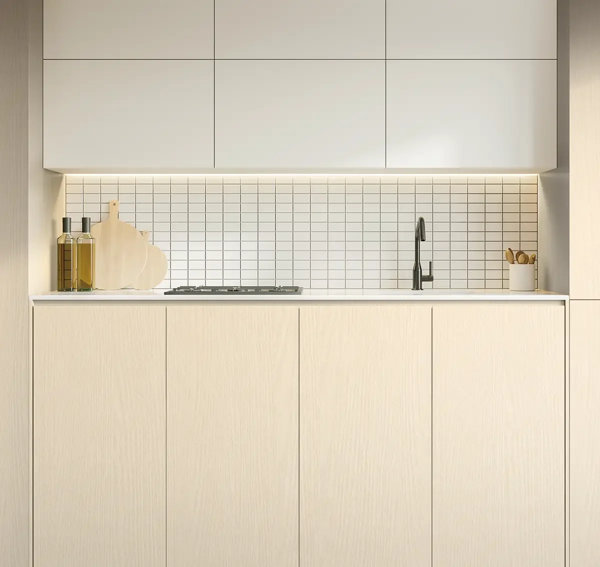 Minimalist kitchen with beige cabinets, white tiled backsplash, black faucet, and countertop accessories including olive oil bottles, cutting boards, and a container with wooden spatulas.