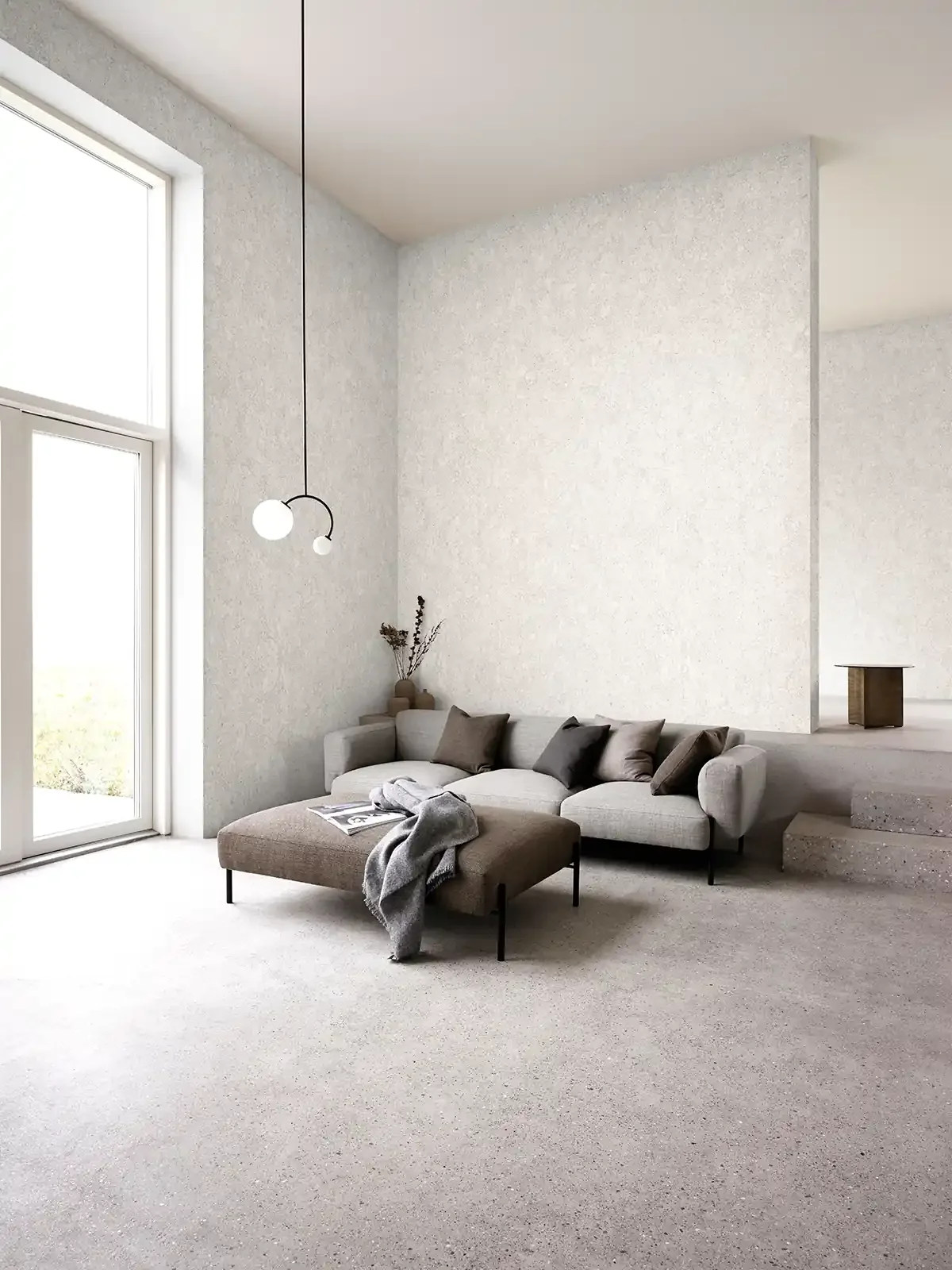 Minimalist living room with beige sectional sofa, brown and black pillows, a large window, and a modern hanging light fixture