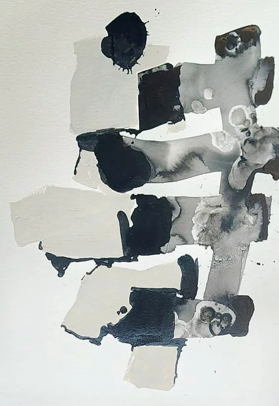 Manchas negras y grises en una hoja de papel que crean un patrón abstracto.